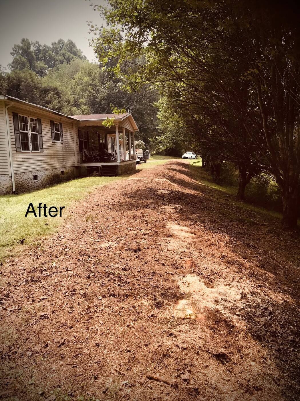 After: trees removed and cleared along the same house, porch view restored